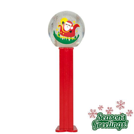 A red PEZ dispenser with a Santa snow globe on the top